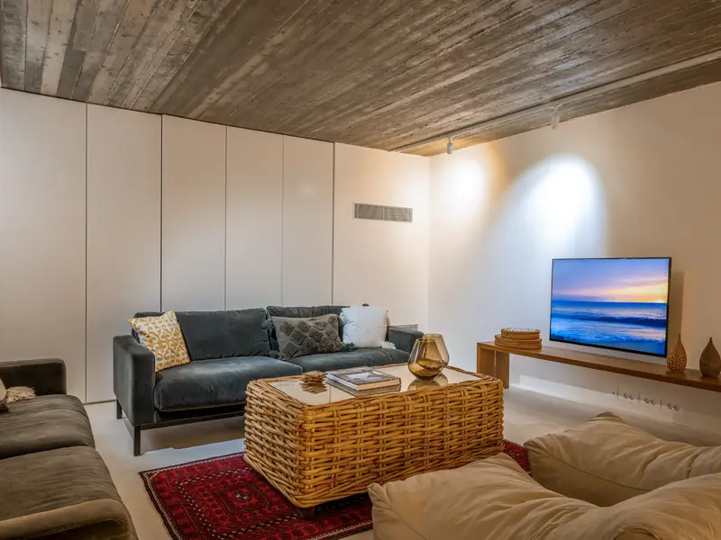 The lounge on the lower floor with sofas and a TV
